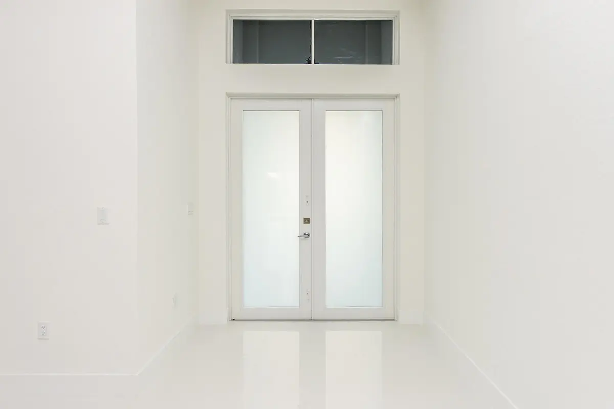 A white door in the middle of a room.