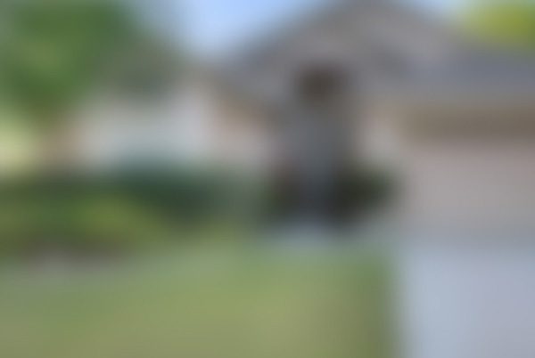 A blurry picture of a house with trees in the background