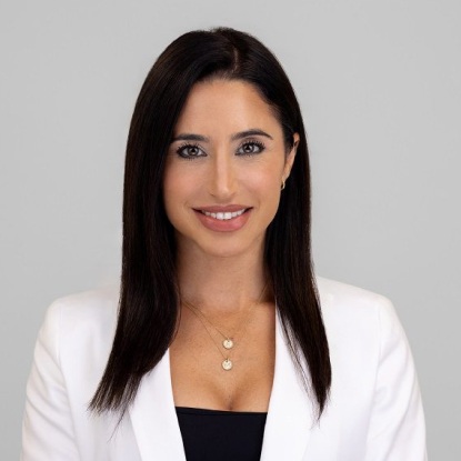 Smiling woman in white blazer portrait.