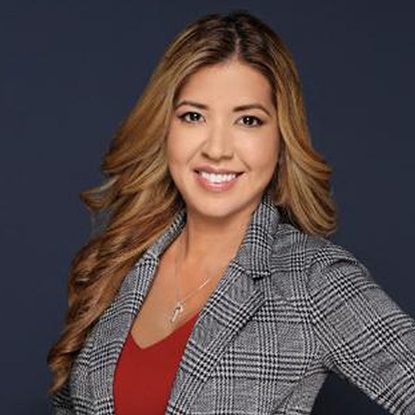 Portrait of a smiling woman in plaid blazer.