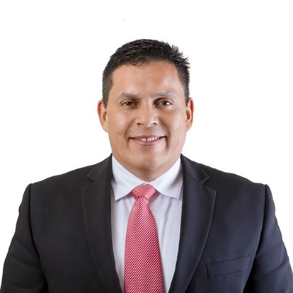 Smiling man in suit with pink tie.