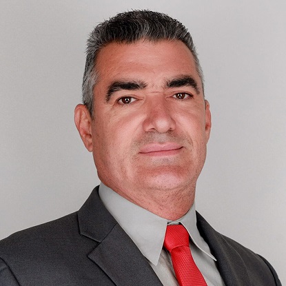 Man in suit with red tie smiling.