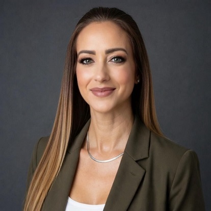 Professional woman in green blazer, smiling.